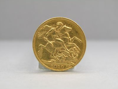 a close up of a gold coin on a white surface