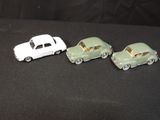 three toy cars sitting next to each other on a black surface