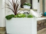 a white planter sitting on the porch of a house