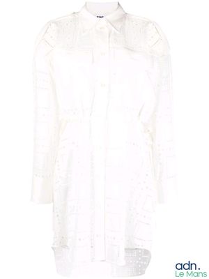 La chemise est blanche et présente un motif en dentelle.