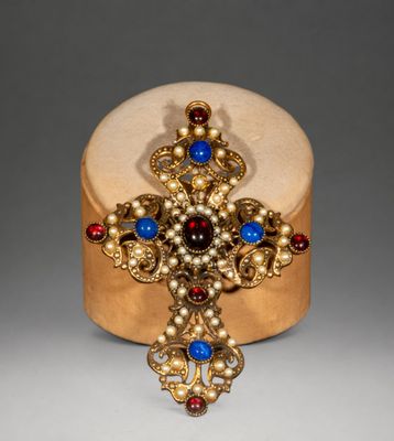 an image of a gold cross with blue and red stones on it