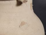 a white vase with a hole in it on a table