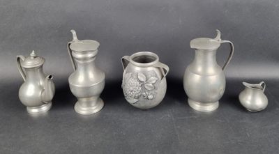 several silver vases and pitchers are lined up on a table