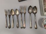 a lot of silver spoons and forks on the table