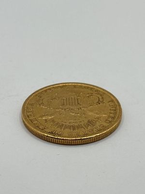 gros plan d'une pièce d'or sur une surface blanche