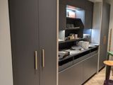 une cuisine équipée d'un plan de travail, de placards et d'un tabouret