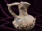 du velours violet sur lequel est posé un vase, le tout sur un tissu violet