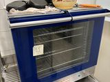 un four bleu posé sur un plan de travail dans une cuisine