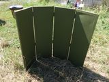 a green folding screen in the middle of a field