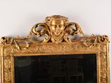 a gold mirror with a face on it in a room