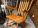 un fauteuil à bascule en bois qui se trouve dans une pièce