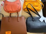several purses are sitting on a table with tags on them