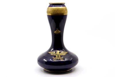 un vase bleu orné d'une décoration dorée