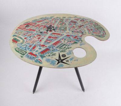une table sur laquelle se trouve une palette de peinture, sur laquelle est posée une carte