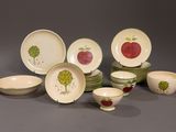 a lot of plates and bowls with apples painted on them