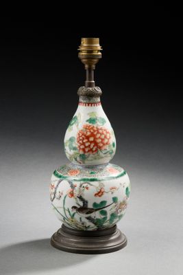un vase oriental orné d'un oiseau et de fleurs, posé sur un socle