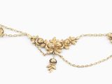 a close up of a gold necklace with flowers and leaves