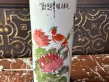 un vase avec un oiseau posé sur une table