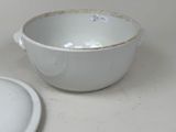 a white bowl with a lid sitting on a table