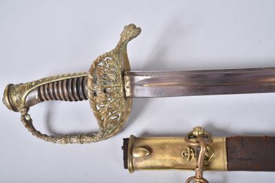 une image représentant une épée avec une poignée en laiton et une poignée en bois