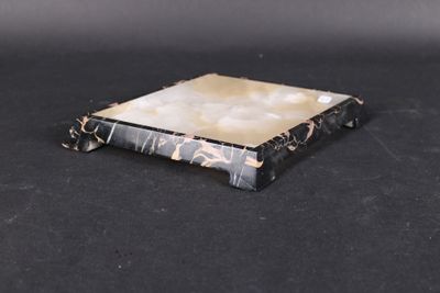 an image of a black and white marble coaster on a black surface