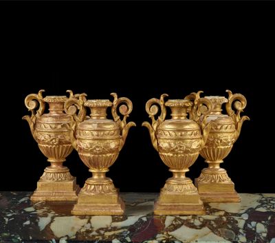 trois vases en or posés sur une table en marbre