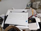 a white laptop sitting on top of a pile of junk