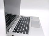 a silver laptop with a black keyboard on a white surface