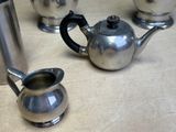 a silver tea pot and a silver teapot on a table