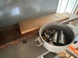 un seau rempli de boîtes de conserve posé sur une étagère dans une pièce