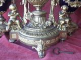 a gold and blue vase with angels and cherensils on it