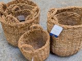 three woven baskets sitting on the ground next to each other