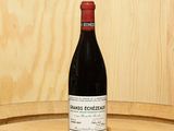 une bouteille de vin posée sur un tonneau
