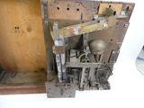 a metal clock that is sitting inside of a wooden box