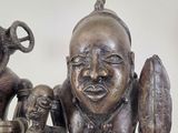 a bronze statue of a man holding a baby and an elephant