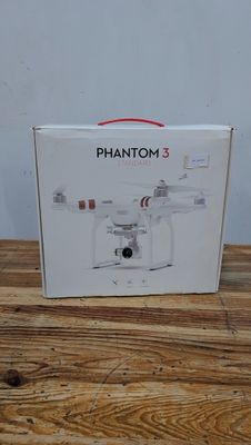 la boîte est ouverte sur une table en bois et contient un drone blanc