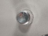 a close up of a silver object on a white surface