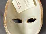 a white mask with a tag attached to it