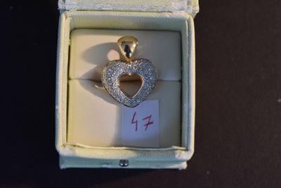 un pendentif en forme de cœur en diamant, présenté dans un écrin avec une étiquette de prix