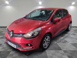une voiture rouge est garée dans une pièce au sol en damier