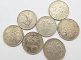 a close up of a bunch of coins sitting on top of a white surface