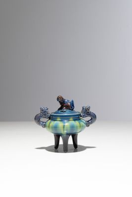un vase bleu et vert posé sur une table