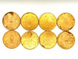 six gold coins are arranged in a row on a white surface