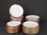 a set of six gold and white plates with red rims