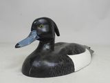 un canard noir et blanc posé sur une surface blanche