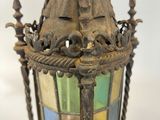 an old fashioned lantern hanging from a metal pole on a white background