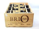 des bouteilles de vin dans une caisse en bois posée sur une surface blanche
