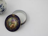 a small blue and white container with a picture of flowers on it