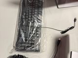 a keyboard, mouse, headphones, and other electronics laid out on a table