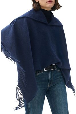 the woman is wearing a blue shawl with fringes on it